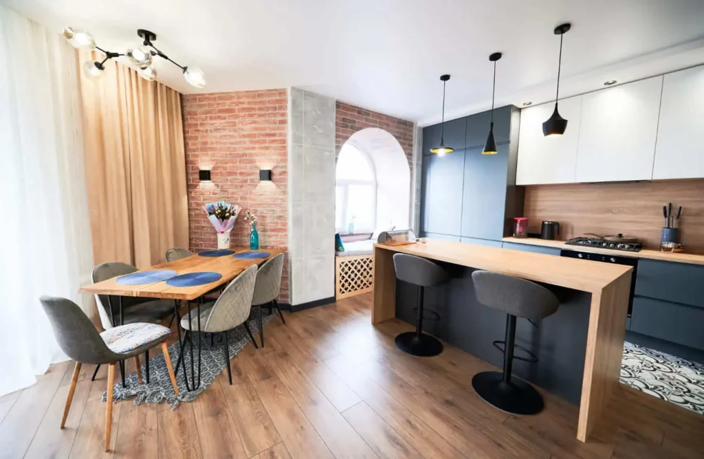 Imagem da parte de dentro de um apartamento moderno, com foco na área integrada da cozinha e sala de jantar para ilustrar matéria sobre como funciona a compra de um apartamento